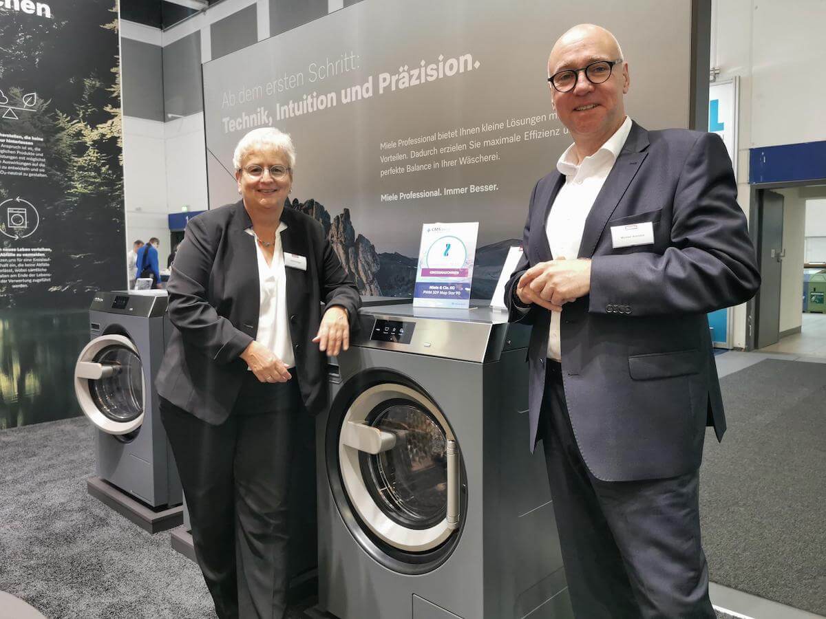 Michael Arendes, Produktmanager Miele Professional (rechts) mit Angelika Schläger, Miele Professional Presse präsentieren gewerbliche Waschmaschinen auf der CMS Messe.